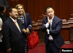 Congressman Kenji Fujimori, right, observes the count of votes as lawmakers decide whether to remove Peru's President Pedro Pablo Kuczynski from office, in Lima, Peru Dec. 21, 2017.