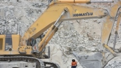 Rosalie Guiro Kulga, 30, excavator-conductor, poses for a photograph beside her engine at the gold mine site in Hounde, Burkina Faso February 11, 2020