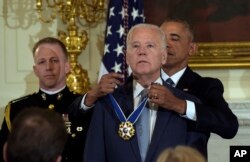 FILE - President Barack Obama presents Vice President Joe Biden with the Presidential Medal of Freedom during a ceremony in the State Dining Room of the White House in Washington, Jan. 12, 2017.