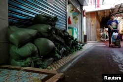 Sandbags are put in front of a shop at Lei Yue Mun, a village as one of the several areas at-risk, as Typhoon Mangkhut approaches Hong Kong, China, Sept. 14, 2018.