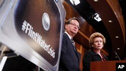 FILE - Sen. Gary Peters, D-Mich., left, and Sen. Debbie Stabenow, D-Mich., discuss proposed legislation to help Flint, Michigan, with its current water crisis during a news conference on Capitol Hill in Washington, Jan. 28, 2016
