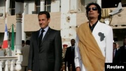 FILE - Libya's President Muammar Gadhafi (R) and his counterpart from France Nicolas Sarkozy listen to national anthems at Bab Azizia Palace in Tripoli, July 25, 2007.
