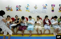 Mothers in Singapore breastfeed their babies during a breastfeeding campaign.