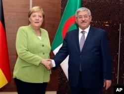 German Chancellor Angela Merkel shakes hands with Algerian Prime Minister Ahmed Ouyahia ahead of talks in Algiers, Sept.17, 2018.
