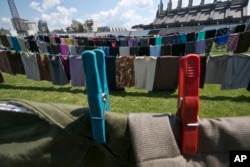 Lines of women's clothing hang, as a part of an art installation called 'Thinking of You,' by Kosovo-born artist Alketa Xhafa Mripa, in Pristina stadium, June 10, 2015.