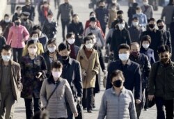 Orang-orang di Pyongyang, ibu kota Korea Utara, memakai masker di tengah pandemi COVID-19, 30 Maret 2020. (Kyodo News/Reuters)