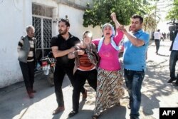 FILE - Residents flee as rockets fired from Syria land in the Turkish town of Kilis, April 19, 2016.