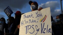 FILE - A man holds a sign as members of the Venezuelan community react after the Biden administration said it would give temporary protected status to Venezuelan migrants living in the United States, in Doral, Florida, March 9, 2021.