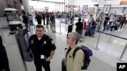 U.S. Customs and Border Protection supervisor Erik Gordon, left, helps a passenger navigate one of the new facial recognition kiosks at a United Airlines gate before boarding a flight to Tokyo, Wednesday, July 12, 2017, at George Bush Intercontinental Air