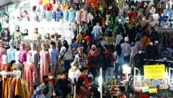 Para pengunjung tetap menggunakan masker saat berbelanja menjelang hari raya Idul Fitri di Pasar Tanah Abang di Jakarta Pusat pada 3 Mei 2021. (Foto: Reuters/Ajeng Dinar Ulfiana)