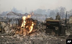 Flames continue to burn near gas lines at a destroyed apartment complex in Middletown, California, Sept. 13, 2015.