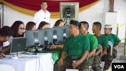 Jacob Palao (front), a rebel deputy commander, gets processed for livelihood assistance for Moro Islamic Liberation Front fighters, in Sultan Kudarat, Maguindanao Province, the Philippines, June 16, 2015. (VOA/Simone Orendain)