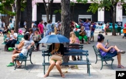 FILE - People surf the Internet at a Wi-Fi hotspot in Havana, Cuba, Nov. 25, 2015.