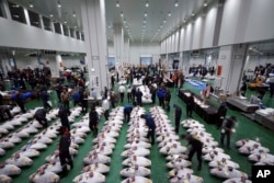 A prospective buyers inspect the quality of tuna before the first auction of the year at the newly opened Toyosu Market, new site of Tokyo's fish market, Jan. 5, 2019, in Tokyo.