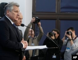 FILE - Former Polish President Aleskander Kwasniewski, left, and former Prime Minister Leszek Miller, second left, who were in power when the CIA ran a secret prison in Poland, speak to reporters in Warsaw about a report on CIA techniques, Dec. 10, 2014.