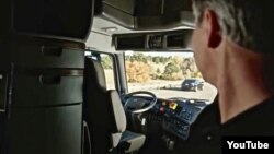 The driver of Otto's self-driving truck relaxes during a 190-kilometer trip through Colorado to transport a full load of Budweiser beer. (Otto/YouTube)