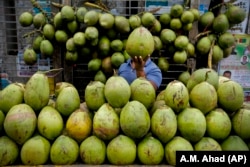A Bangladeshi street vendor sells coconut on a street in Dhaka, Bangladesh, 2016. (AP Photo/ A.M. Ahad)