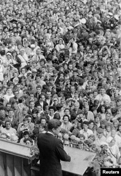 U.S. President John F. Kennedy, standing on a rostrum, addresses a large crowd in the main square in front of Schoeneberg City Hall in West Berlin, Germany, June 26, 1963.