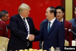 Vietnam's President Tran Dai Quang welcomes U.S. President Donald Trump with a state banquet at the International Convention Center in Hanoi, Vietnam, Nov. 11, 2017.