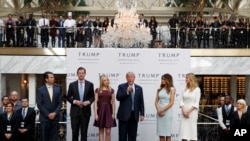 FILE - Then-candidate Donald Trump, accompanied by his family, speaks during the grand opening of the Trump International Hotel-Old Post Office, Washington, Oct. 26, 2016. Experts on government ethics are warning President-elect Trump that he’ll never shake the appearance of conflict of interest.