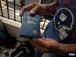 Mario Hernandez holds up a copy of the New Testament, one of the few items he carried with him on his journey north, from Chiquimulilla, Guatemala, to Mexicali, Mexico. (R. Taylor/VOA)