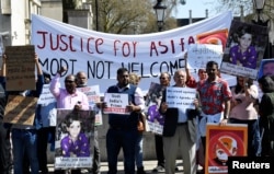Demonstrators carry placards demanding justice for Asifa, an 8-year-old girl who was raped and murdered in India, during a rally protesting a visit by Indian Prime Minister Narendra Modi, in London, April 18, 2018.