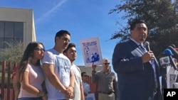 The family of Guadalupe Garcia de Rayos stands behind her attorney, Ray Ybarra Maldonado, as he speaks in front of the U.S. Immigration and Customs Enforcement office in Phoenix. Garcia de Rayos was deported Feb. 9, 2017.