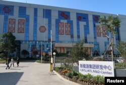 FILE - People walk at the R&D center of Contemporary Amperex Technology Ltd. in Ningde, Fujian province, China, Dec. 16, 2016.