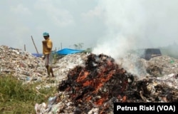 Proses pembakaran sampah plastik sisa pemilahan yang tidak laku dijual. (Foto: Petrus Riski/VOA)
