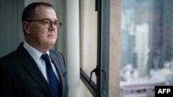 Michael Vidler, lawyer for two young Saudi sisters who have adopted the aliases Reem, 20, and Rawan, 18, poses in his office during an interview with AFP in Hong Kong, Feb. 22, 2019.
