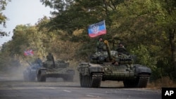 FILE - Russia-backed rebel tanks with a flag of the self-proclaimed Donetsk People's Republic are seen near Novoazovsk, eastern Ukraine, Oct. 21, 2015.