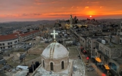Kubah Gereja Asyur yang menghadap menara masjid di Manger Square di Tepi Barat yang diduduki Israel, 24 Desember 2018. (Foto: Reuters)