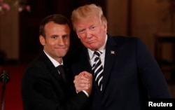 French President Emmanuel Macron clasps hands with U.S. President Donald Trump at the conclusion of their joint news conference in the East Room of the White House in Washington, U.S., April 24, 2018.