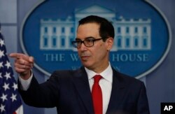 FILE - Treasury Secretary Steven Mnuchin points to a reporter during the news briefing at the White House, in Washington, Aug. 25, 2017.