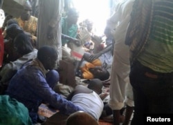 Injured people are comforted at the site of a bombing attack of an internally displaced persons camp in Rann, Nigeria, Jan. 17, 2017.