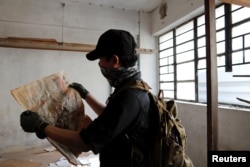 A HK URBEX member looks at a newspaper from 1982 inside an abandoned residential building in Hong Kong, China, June 7, 2017.