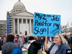 Melissa Knight, who teaches art at Ardmore, Oklahoma, middle school, holds a sign as teachers rally against low school funding at the state Capitol in Oklahoma City, April 2, 2018.