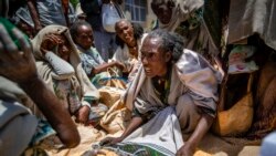 FILE - An Ethiopian woman argues with others over the allocation of yellow split peas distributed by the Relief Society of Tigray in the town of Agula, in the Tigray region of northern Ethiopia, on May 8, 2021.