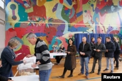 People wait in line to vote during the second round of 2017 French presidential election at a polling station in Bron, France, May 7, 2017.