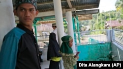 Local young people wait for a Quran reading class to start at a mosque in a village which is feared will be affected by the expansion of the Asia Pulp & Paper, a company part of Indonesian corporation Sinarmas, in West Bangka, Indonesia.