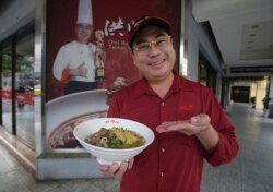 Chef Hung shows pineapple beef noodle outside of his restaurant in Taipei, Taiwan, Wednesday, March 10, 2021. (AP Photo/Chiang Ying-ying)