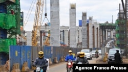 FILE - Motorists drive on Mombasa road, next to the ongoing construction site of the Nairobi Expressway, undertaken by the Chinese contractor China Road and Bridge Corporation (CRBC), in Nairobi, Kenya, July 12, 2021.