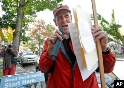Robby Stern, a volunteer with the Puget Sound Advocates for Retirement Action and a proponent of Initiative 1501, leads a small protest over access for health care for senior citizens in Seattle, Oct. 18, 2016. The initiative would stiffen some penalties for identity theft and consumer fraud when seniors or disabled citizens are targeted.