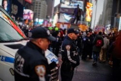 Petugas Kepolisian New York mengawasi para demonstran anti-perang di Times Square, New York, Sabtu, 4 Januari 2020, di tengah peningkatan ketegangan antara AS dan Iran. (Foto: Reuters)