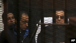 Ousted Egyptian president Hosni Mubarak (R), 86, lies on a gurney in the defendants cage during a court hearing in Cairo, Egypt, Nov. 29, 2014.