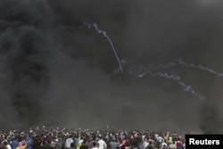 Tear gas canisters are fired by Israeli troops toward Palestinians during clashes at a protest demanding the right to return to their homeland, at the Israel-Gaza border in the southern Gaza Strip, April 20, 2018.