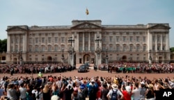 FILE - Queen Elizabeth II leaves Buckingham Palace with Prince Charles to travel to parliament for her speech at the official State Opening of Parliament in London.