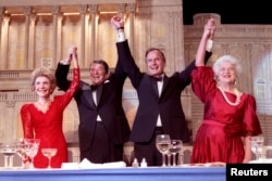 1988年5月11日，在总统晚宴上，美国总统罗纳德·里根宣布支持·布什副总统竞选总统，他们同夫人南希·里根和芭芭拉·布什携手举起臂膀。