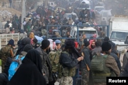 Rebel fighters and civilians gather as they wait to be evacuated from a rebel-held sector of eastern Aleppo, Syria, Dec. 16, 2016.