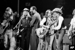 FILE - In this Dec. 1975 file photo, musicians Roger McGuinn, Joni Mitchell, Richie Havens, Joan Baez and Bob Dylan perform the finale of the The Rolling Thunder Revue, a tour headed by Dylan.